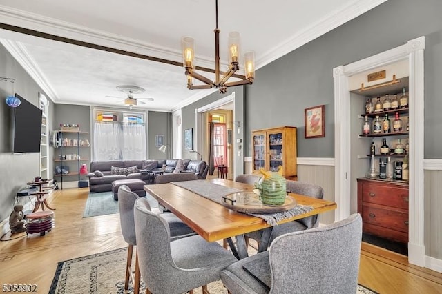 128 W High St, Somerville Boro, NJ 08876 - dining space featuring ornamental molding, a chandelier, ceiling fan, wood finished floors, and a wainscoted wall