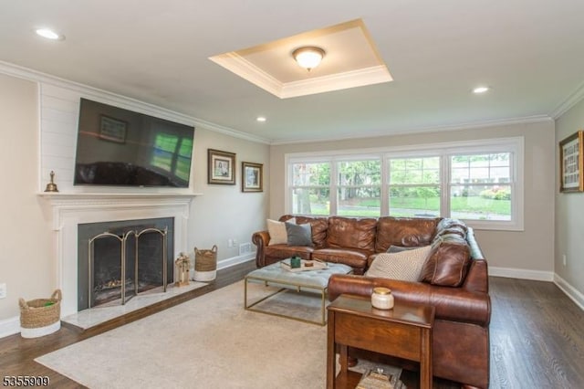 living room with ornamental molding, wood finished floors, baseboards, a fireplace, and recessed lighting
