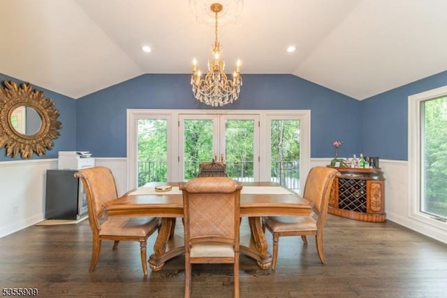 dining space with lofted ceiling, wainscoting, a chandelier, wood finished floors, and french doors