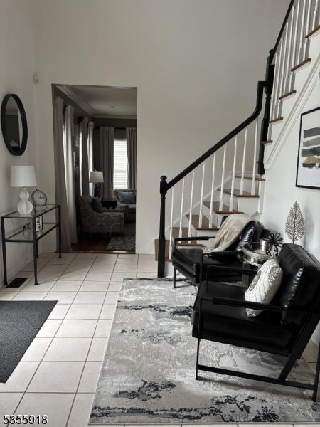 living room with stairway and light tile patterned floors