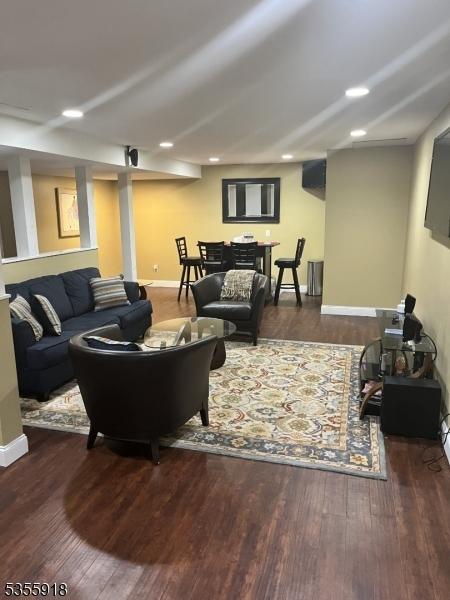 living room with wood finished floors, baseboards, and recessed lighting