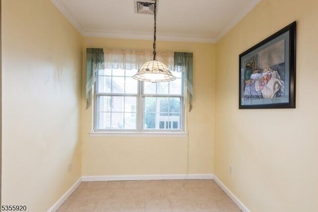 spare room featuring crown molding and baseboards