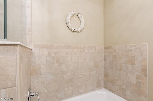 bathroom featuring a tub and a shower