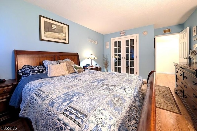 bedroom with french doors and wood finished floors