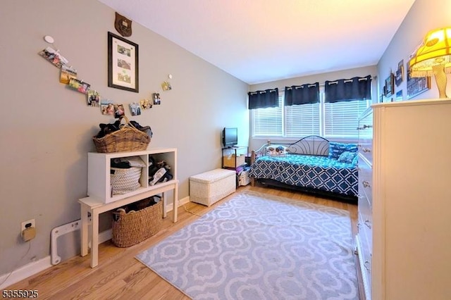 bedroom with wood finished floors and baseboards