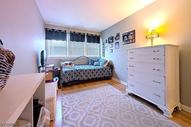 bedroom with wood finished floors and baseboards
