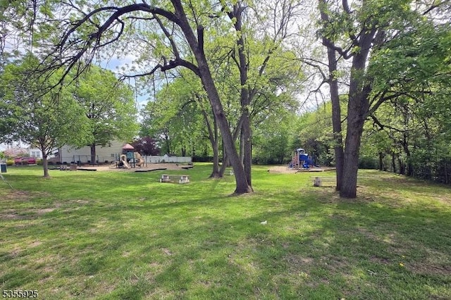 view of green lawn with a playground