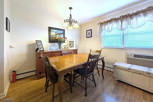 dining room featuring baseboard heating, wood finished floors, a baseboard radiator, and a chandelier