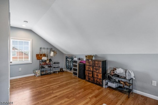 bonus room with wood finished floors, lofted ceiling, and baseboards