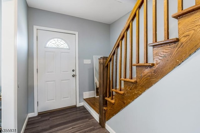 foyer with dark wood-type flooring, stairs, and baseboards