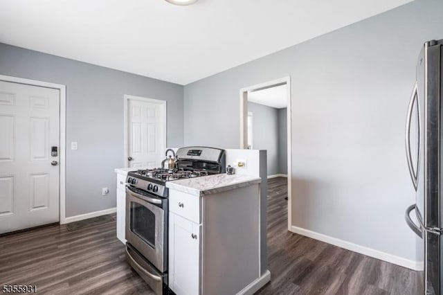 kitchen with stainless steel appliances, baseboards, dark wood-style floors, and white cabinetry