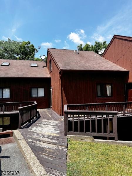 view of front of house featuring a deck and roof with shingles