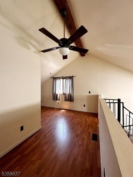 additional living space featuring dark wood-type flooring, a ceiling fan, and baseboards