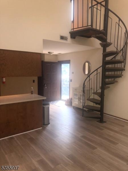 stairs with a high ceiling and wood finished floors