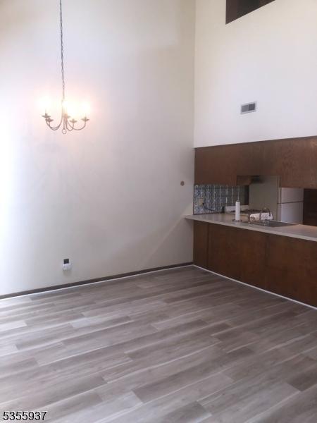 unfurnished dining area featuring a chandelier, wood finished floors, and a sink