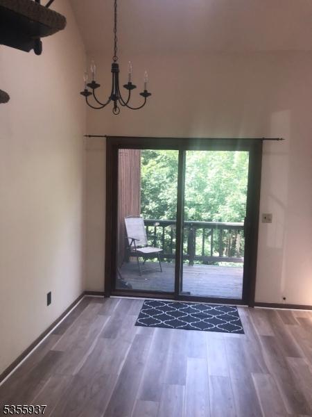 entryway with a chandelier, wood finished floors, and baseboards