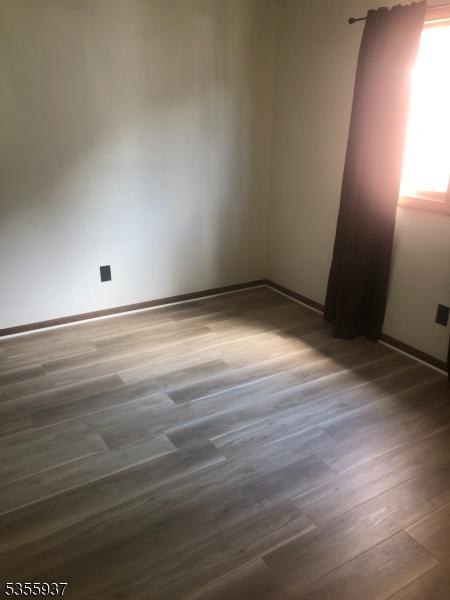 unfurnished room with wood finished floors and baseboards