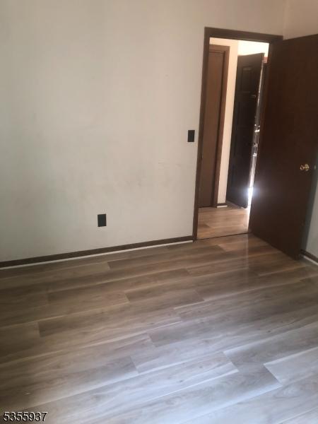 spare room with wood finished floors and baseboards