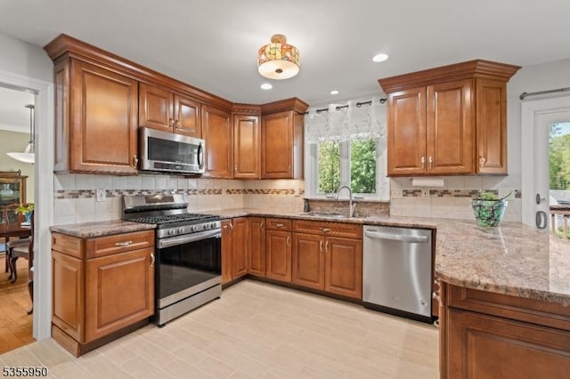 53 Woodland Ave, Morris Twp, NJ 07960 - kitchen with appliances with stainless steel finishes, a sink, brown cabinets, light stone counters, and recessed lighting