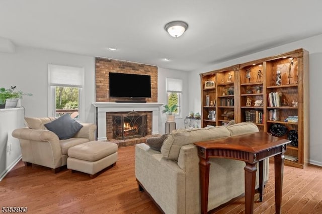 53 Woodland Ave, Morris Twp, NJ 07960 - living area featuring light wood-type flooring, a brick fireplace, and baseboards