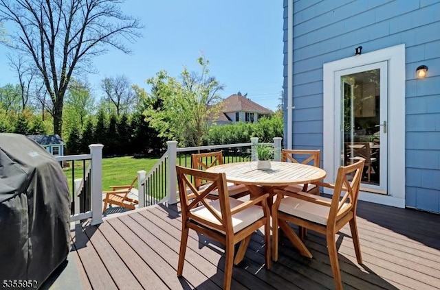 wooden deck featuring outdoor dining area and a grill