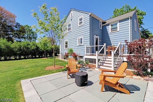 back of house featuring a lawn, a patio, and a deck