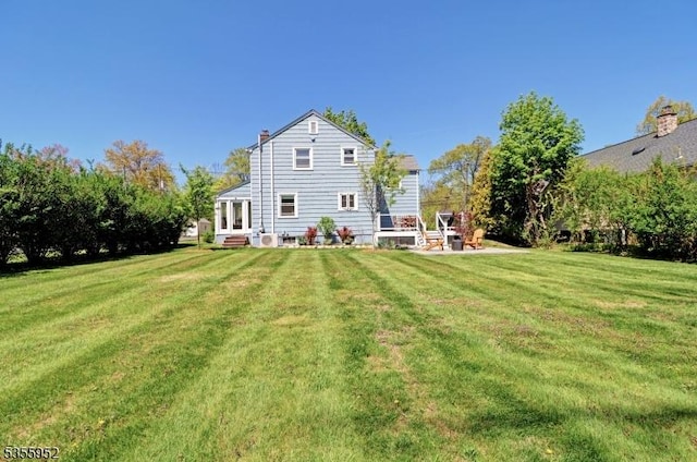 back of property featuring a yard and entry steps