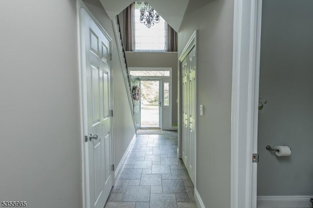 hallway featuring baseboards and stone tile floors