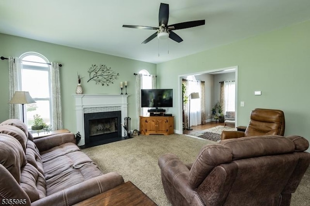 carpeted living area featuring ceiling fan and a fireplace with flush hearth