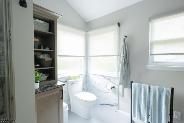 bathroom featuring lofted ceiling, toilet, and vanity