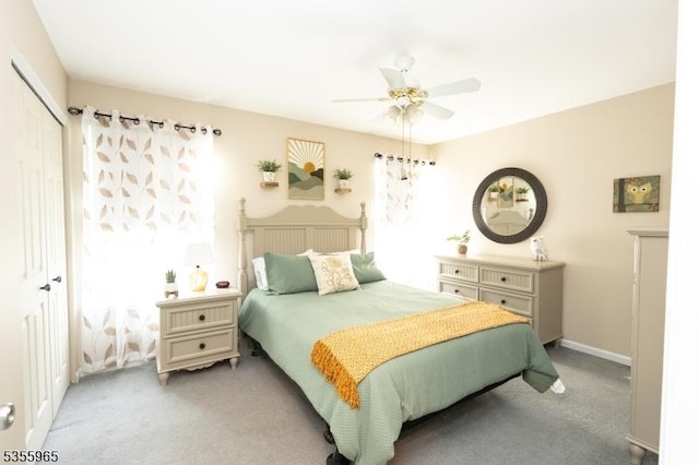 bedroom featuring light colored carpet, a closet, and a ceiling fan