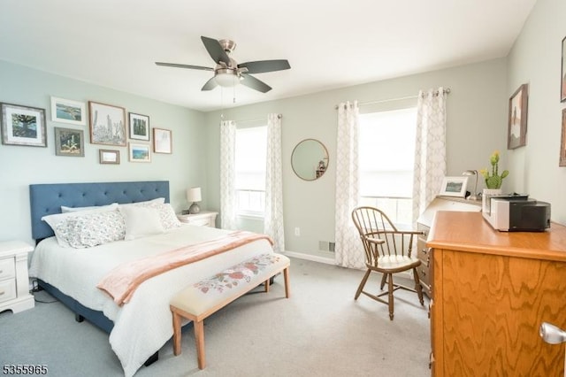 bedroom with light carpet, an office area, and ceiling fan