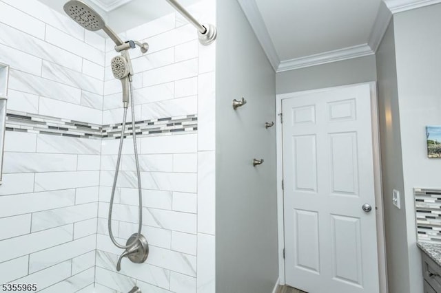 full bath featuring ornamental molding, tiled shower, and vanity