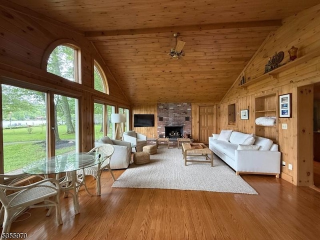 217 Bearfort Rd, West Milford Twp, NJ 07480 - living area featuring high vaulted ceiling, wooden walls, wood ceiling with exposed beams, wood finished floors, and a fireplace
