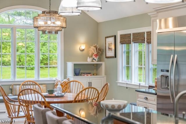 dining area featuring healthy amount of natural light, a chandelier, and lofted ceiling