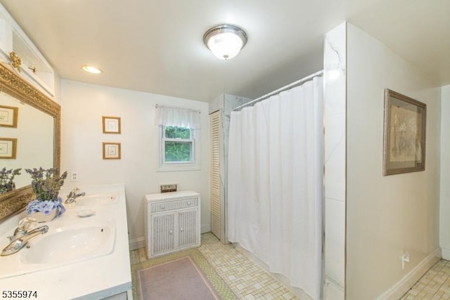 bathroom featuring baseboards, double vanity, and a shower with curtain