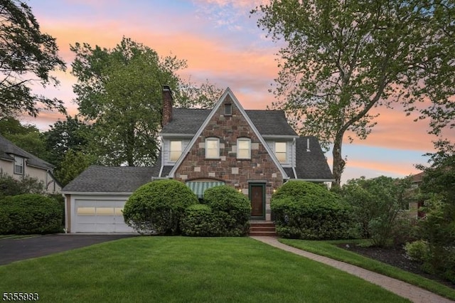 10 Highland Pl, West Orange Twp, NJ 07052 - english style home featuring a chimney, asphalt driveway, stone siding, and a front yard