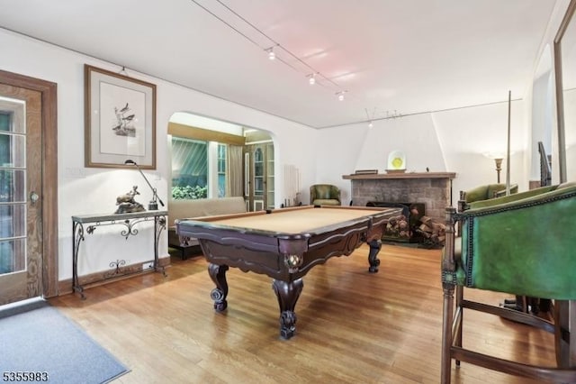 10 Highland Pl, West Orange Twp, NJ 07052 - playroom with billiards table, light wood-style flooring, a stone fireplace, track lighting, and arched walkways