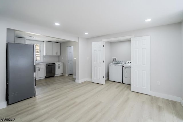 kitchen featuring freestanding refrigerator, black dishwasher, washing machine and clothes dryer, recessed lighting, and light wood-type flooring