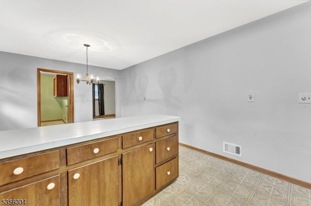 45 Ninth St, Hillsborough Twp, NJ 08821 - kitchen with light countertops, brown cabinetry, light flooring, a chandelier, and hanging light fixtures