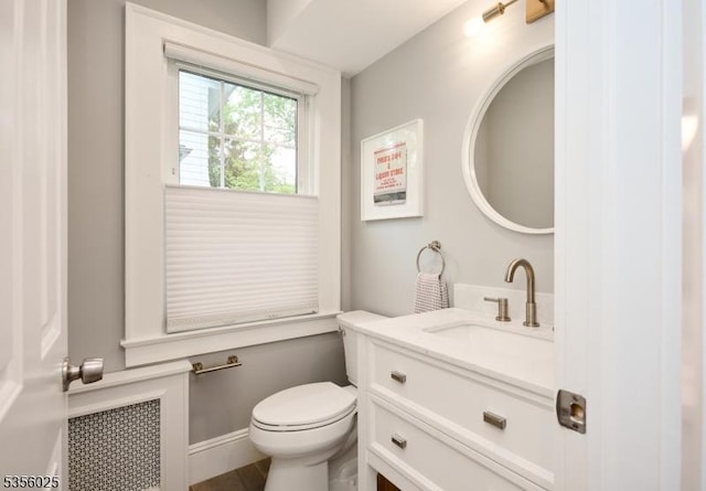 bathroom with toilet, vanity, and radiator