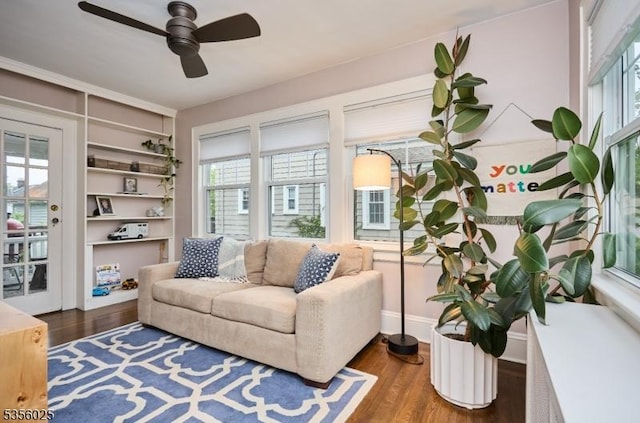 sitting room with plenty of natural light, a ceiling fan, and dark wood-style flooring