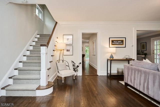 stairs with wood finished floors, ornamental molding, and baseboards