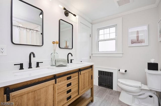 full bath with radiator, toilet, crown molding, wood finished floors, and double vanity