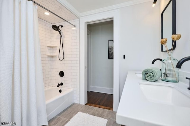 bathroom with a sink, ornamental molding, shower / tub combo with curtain, wood finished floors, and baseboards