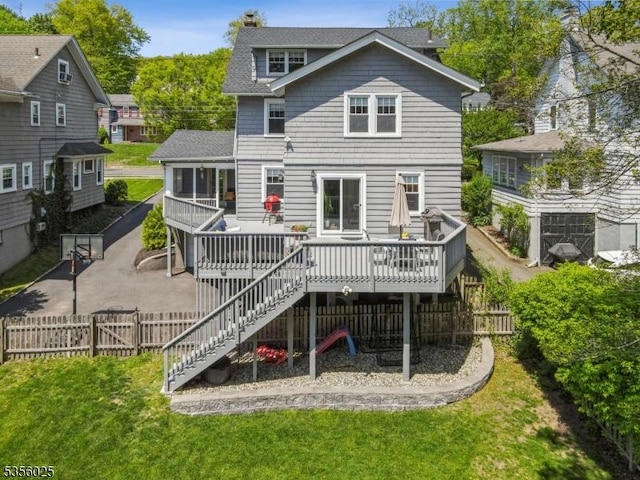 back of property featuring a deck, stairway, a gate, a patio area, and a shingled roof