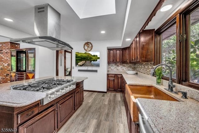 142 Decker Rd, Rockaway Twp, NJ 07005 - kitchen featuring island range hood, stainless steel gas cooktop, light wood finished floors, light stone countertops, and backsplash