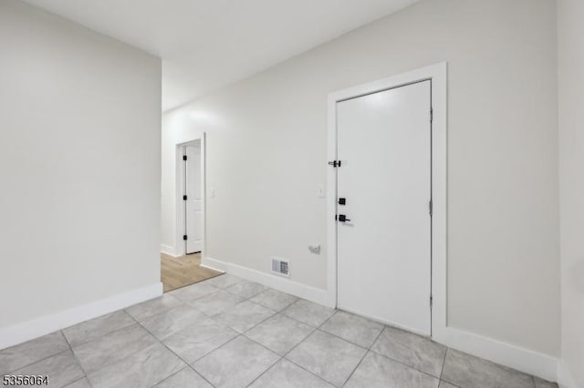 spare room with light tile patterned flooring and baseboards