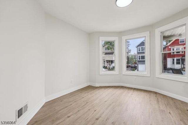 spare room with wood finished floors and baseboards