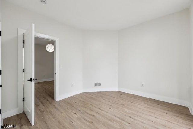 empty room featuring wood finished floors and baseboards